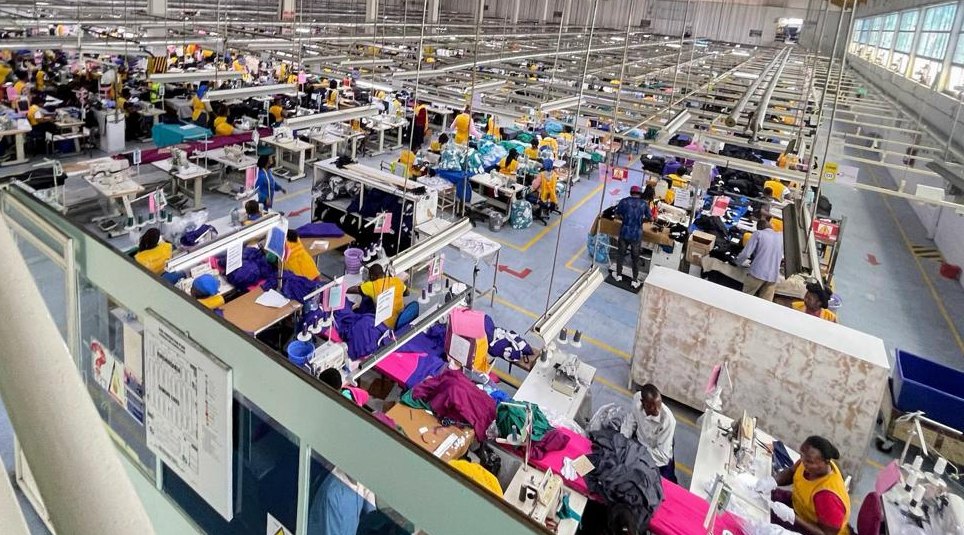 Garment factory floor with long rows of industrial sewing machines