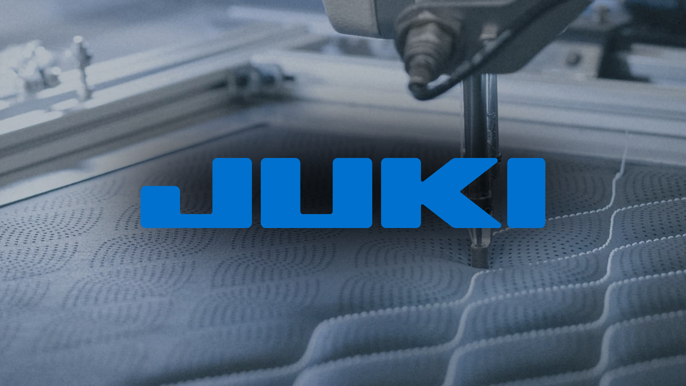 Juki industrial lockstitch sewing line on a garment floor